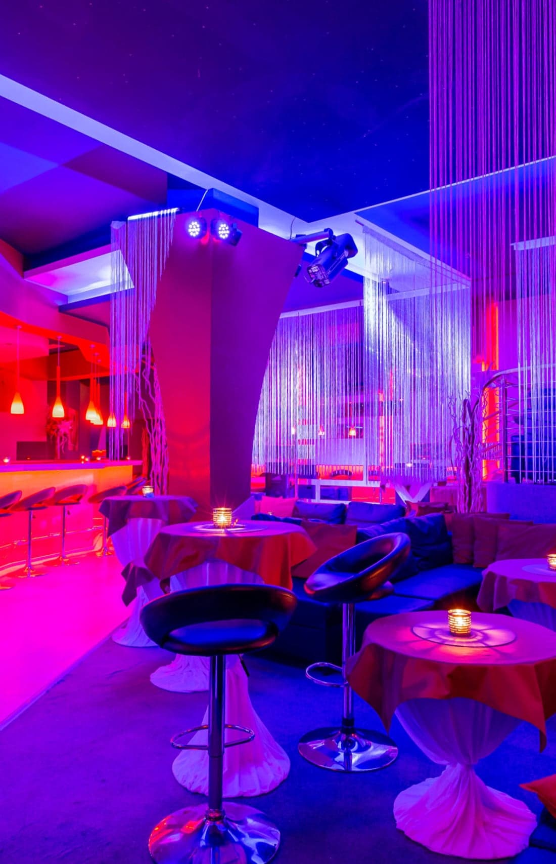 Interiér Swingers Fantasy klubu: bar, lounge a tematické pokoje v neonovém osvětlení